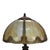 This antique table lamp, in the manner of Bradley & Hubbard, features a domed shade composed of six panels of variegated...