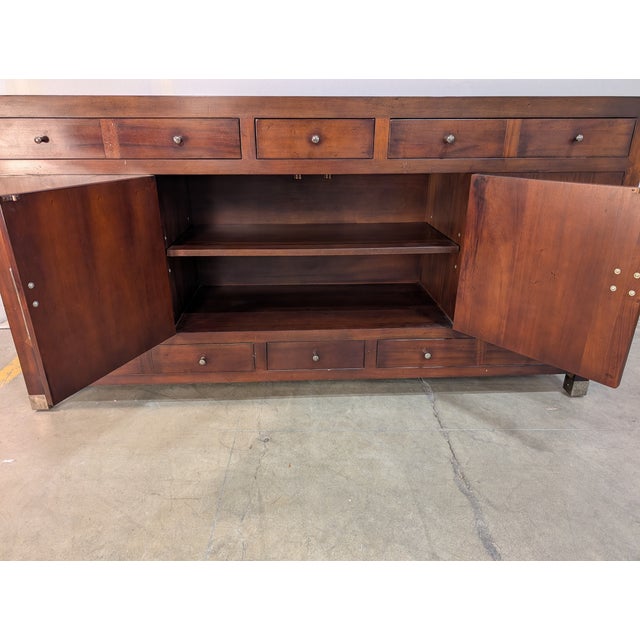 An elegant Ming-style sideboard by Baker, expertly crafted from solid mahogany and distinguished by its rich, finely...