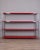 Shelf unit with a chromed metal frame and red plastic shelves. The shelf height can be adjusted using clamps. Industrial...