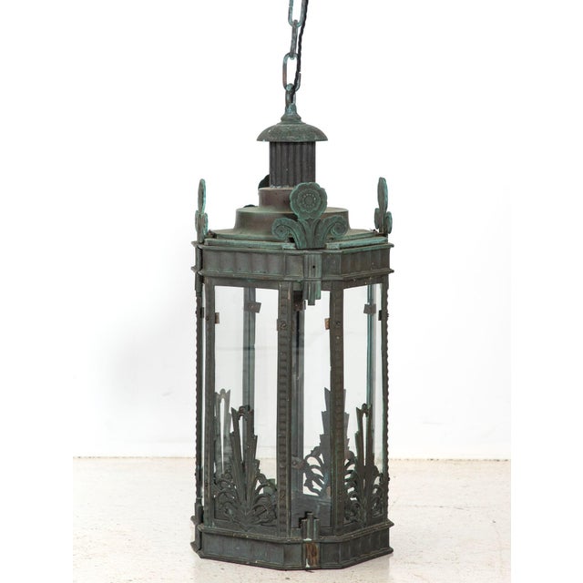 This Art Deco bronze lantern has strong geometric lines, floral corner motifs, and a naturally aged verdigris patina. The...