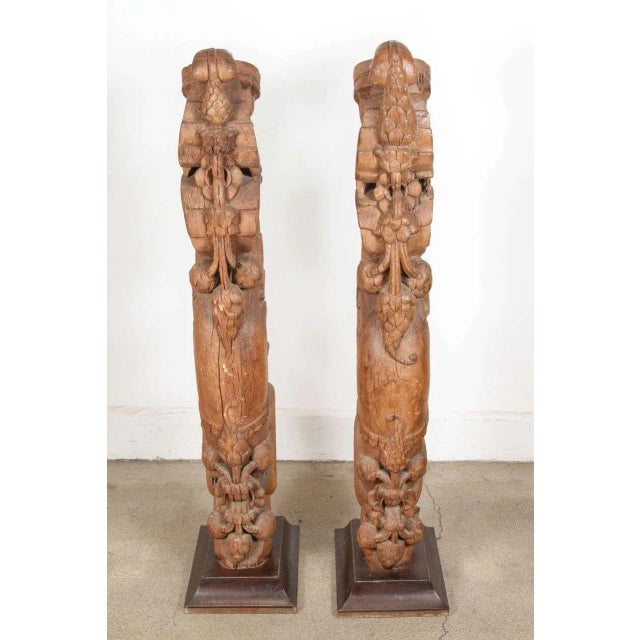 An impressive pair of antique Indian hand-carved wood architectural fragments, now mounted on custom wood stands for...