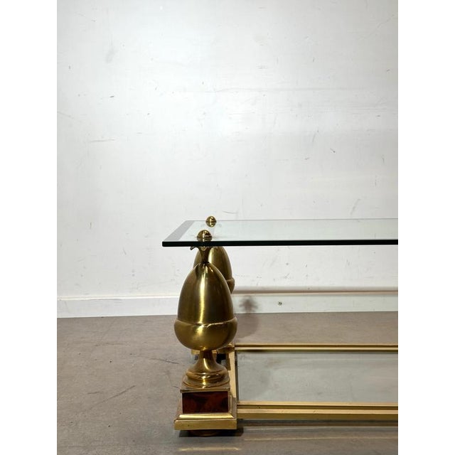 Elegant French coffee table by Maison Charles , executed in polished brass with a clear glass top and a mirrored lower...