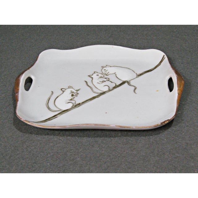 A tiny, delightful plate that feels like it came straight from a turn-of-the-century china-painting studio: three little...