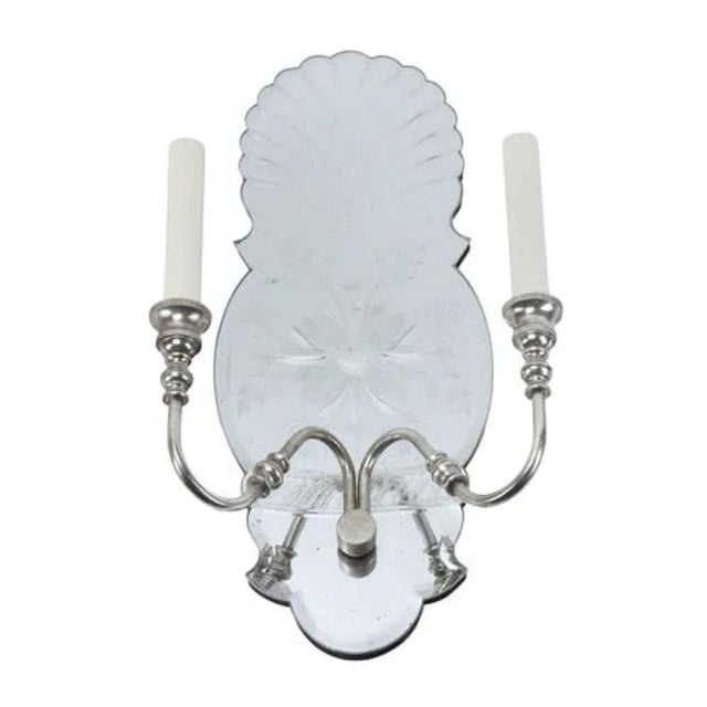 A pair of Hollywood Regency style cut mirrored double arm wall sconces that bring refined sparkle and classic charm to any...