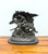 A dramatic solid bronze equestrian sculpture in the style of Frederic Remington, depicting a Native American rider urging...