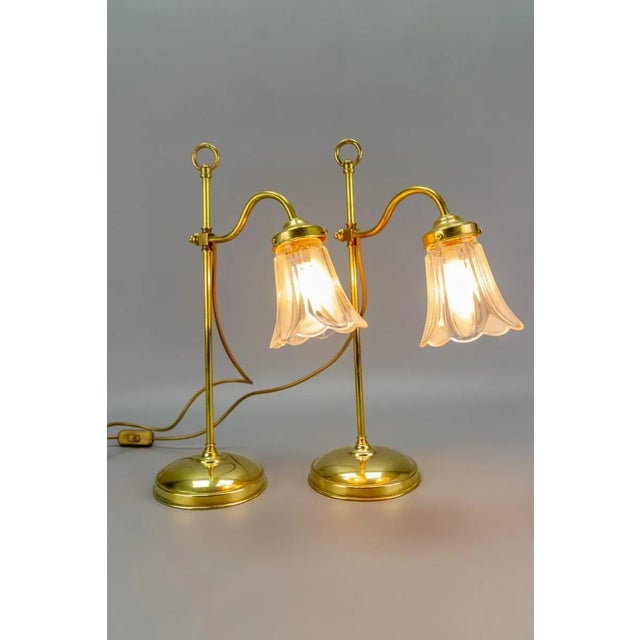 - Set of two elegant Art Nouveau-style table lamps. - Made from brass with a flower-shaped glass shade. - Adjustable...