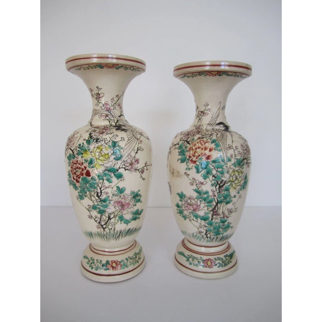 A beautiful pair of Japanese earthenware 'bisque' colored vases with a raised floral, butterfly and 'phoenix' bird relief,...