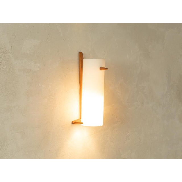 Classic 1960s Scandinavian-style wall lamp by Uno & Östen Kristiansson for Luxus. The lamp features a frosted glass shade...