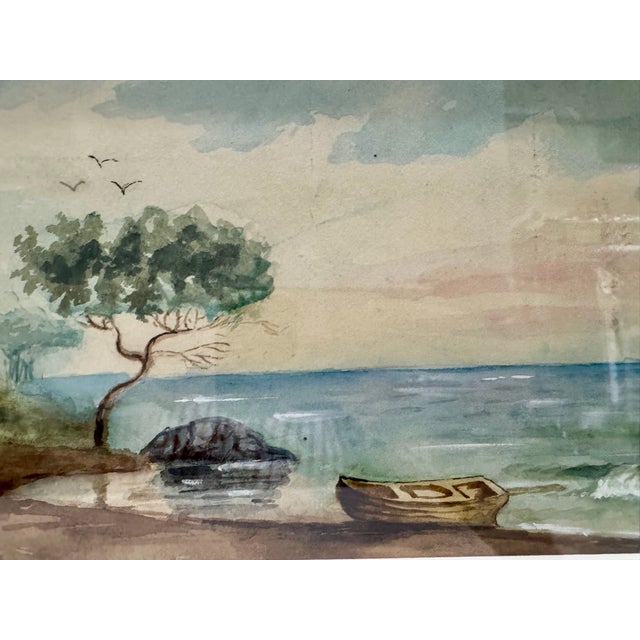 Antique watercolor coastal landscape featuring a shoreline scene with a tree, small boat, rocks, water, and birds in the...