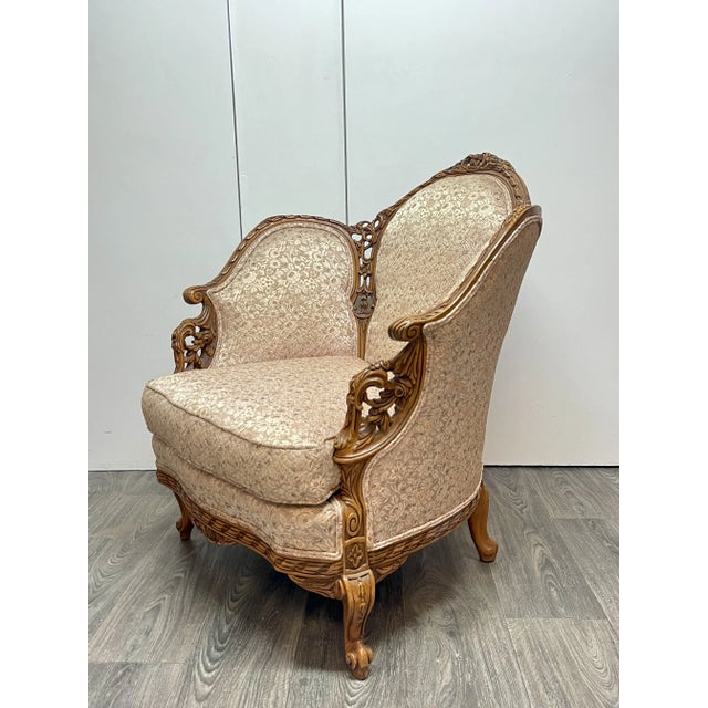 Early 1900’s Louis XV style lounge chair. Very detailed, hand carved frame, pale pink floral embroidered fabric. Golden...