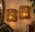 Striking vintage pair of Hollywood Regency amber beaded candle sconces featuring a densely layered arrangement of...