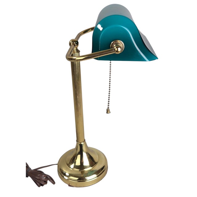 A classic banker's desk lamp featuring a brass-tone metal base and adjustable arm paired with a glass shade in a blue-...
