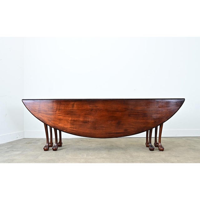 An incredible English drop-leaf dining table with a set of 8 carved-back chairs. This set was made from solid mahogany in...