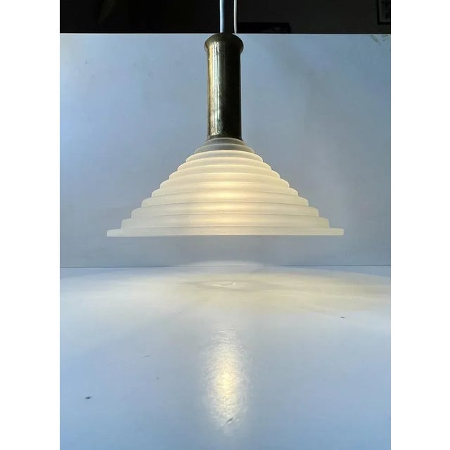 A stylish, unusual and possibly bespoke ceiling lamp composed of a frosted and architecturally 'staired' glass shade and...