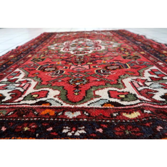 A beautiful handmade antique Persian Hamadan rug, dating from the 1920s, featuring a richly detailed floral medallion...