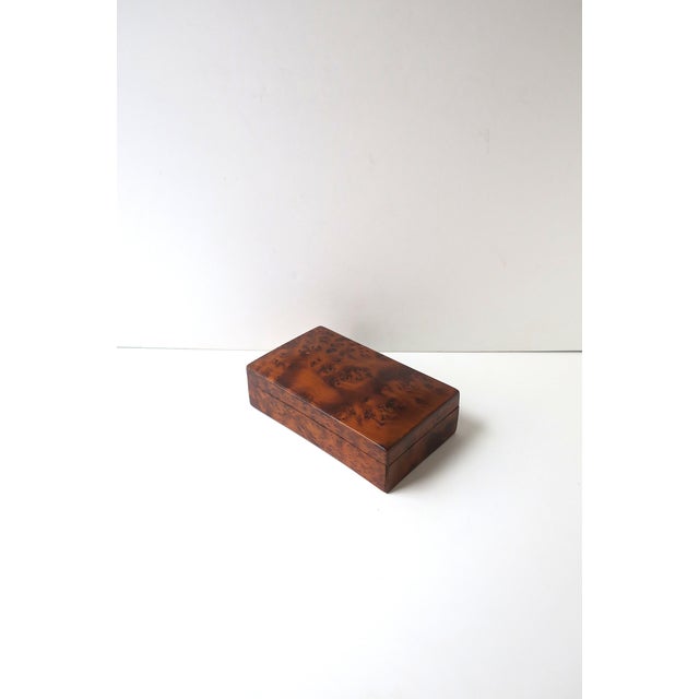 A rectangular burl wood box, in the Modern design style, circa mid-20th century, Europe. Crafted in a rich burl with a...
