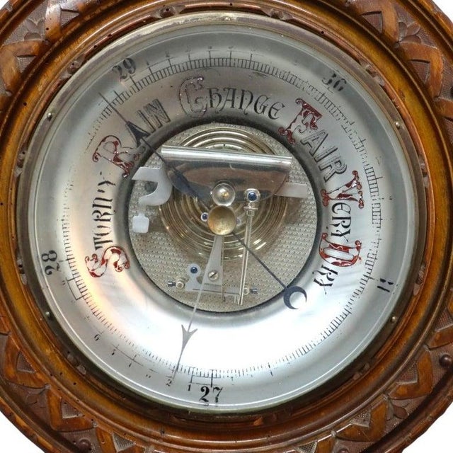 An antique aneroid barometer from the late Victorian era, dating to circa 1900. This scientific instrument is housed in a...