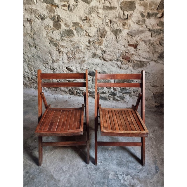This set of two vintage French folding chairs dates from the 1970s and is crafted from solid beech wood. The design is...