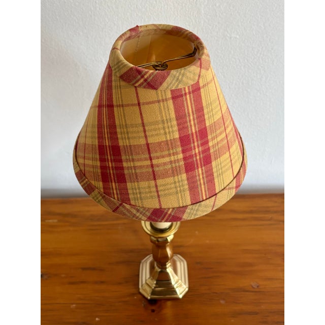 Small brass candlestick lamp with a pretty plaid shade in yellow ochre and red burgundy. Please see condition details...