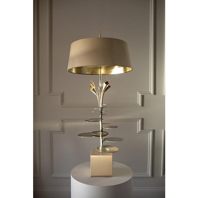 A Hollywood Regency sculptural beauty that doubles as art. Featuring a brass stem with floral inspired accents and lily...