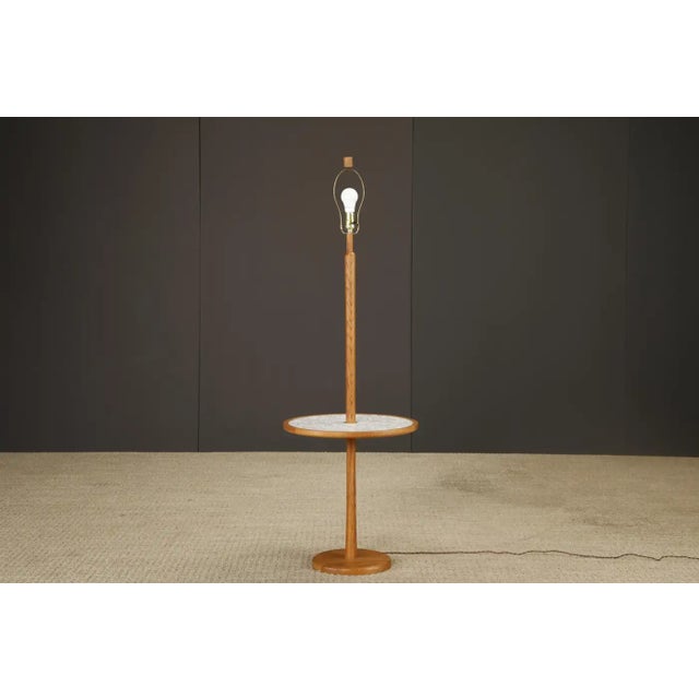 This classy 1960s stained oak floor lamp with built-in ceramic tile side table by Gordon and Jane Martz for Marshall...