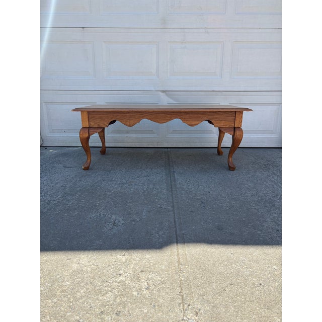 We have a beautiful, vintage oak Queen Anne style coffee table for sale. This piece features elegant cabriole legs, a...