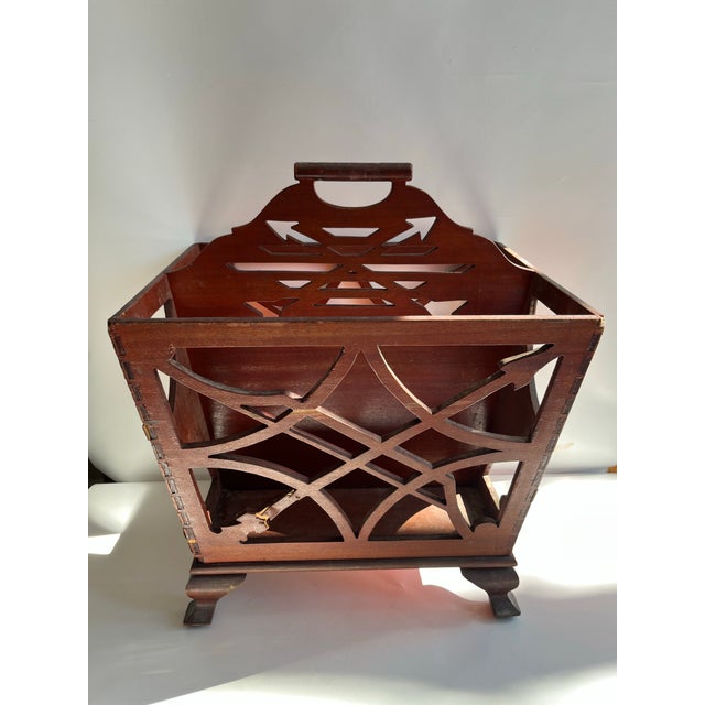 A single antique reticulated wood magazine rack or newspaper holder with handle and feet. Features chippendale style...