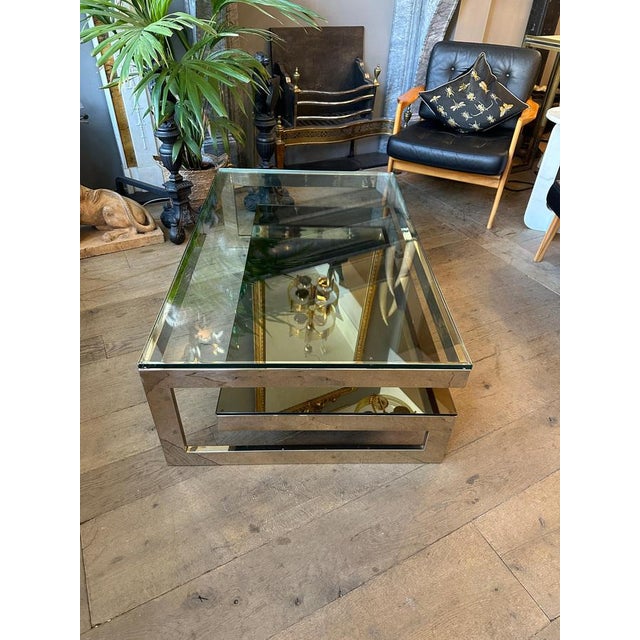 A large two tiered coffee or cocktail table in gold plated chrome, with bottom top bronze mirrored and top tinted...