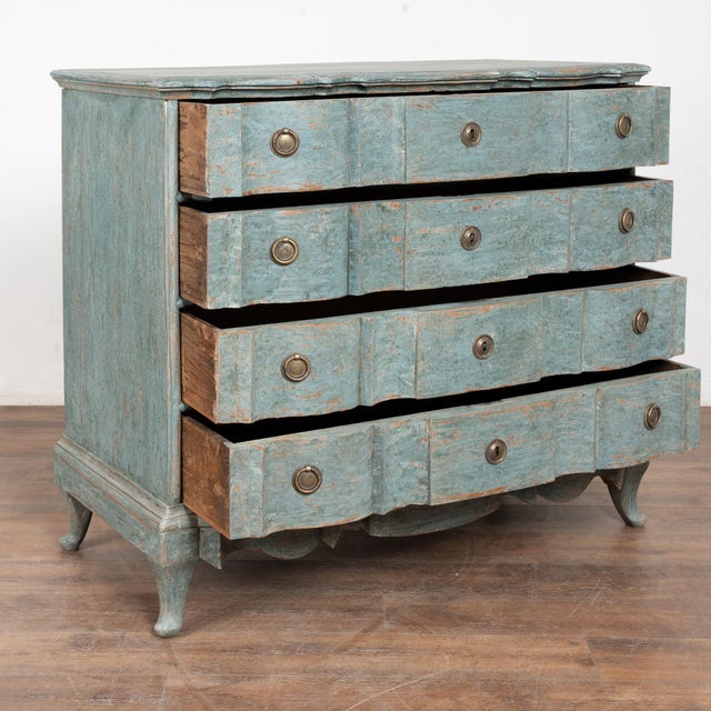 This large antique rococo oak chest of drawers features a serpentine front, carved skirt and brass hardware pulls. It has...