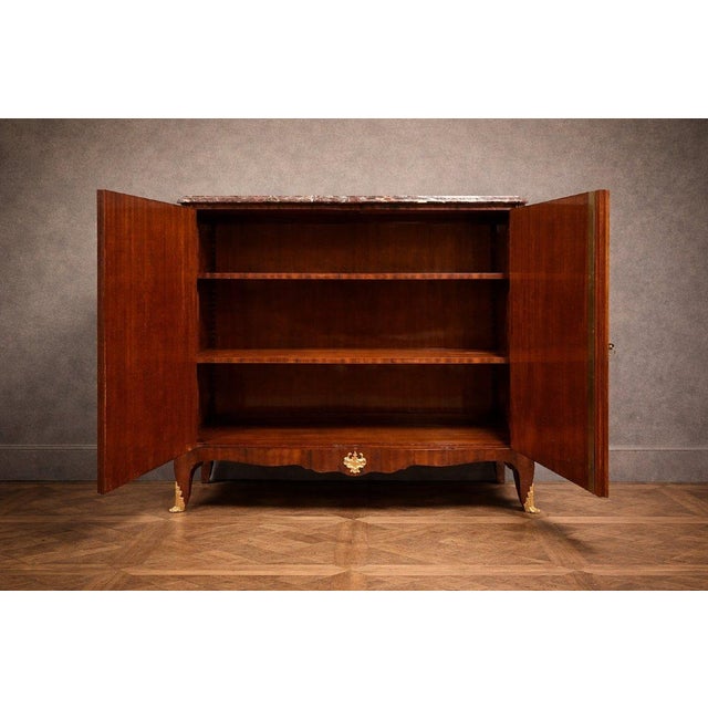 A large, high-sided commode made of precious wood, richly inlaid with floral motifs, typical of the louis xv style, dating...