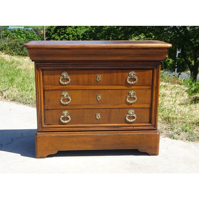 Beautiful chest of drawers in a honey-gold color, with four drawers, one of which is curved. Gilt bronze handles and...