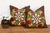 A radiating medallion in mustard-gold, worked as stylized wing-like forms reaching outward, frames a cluster of red flower...