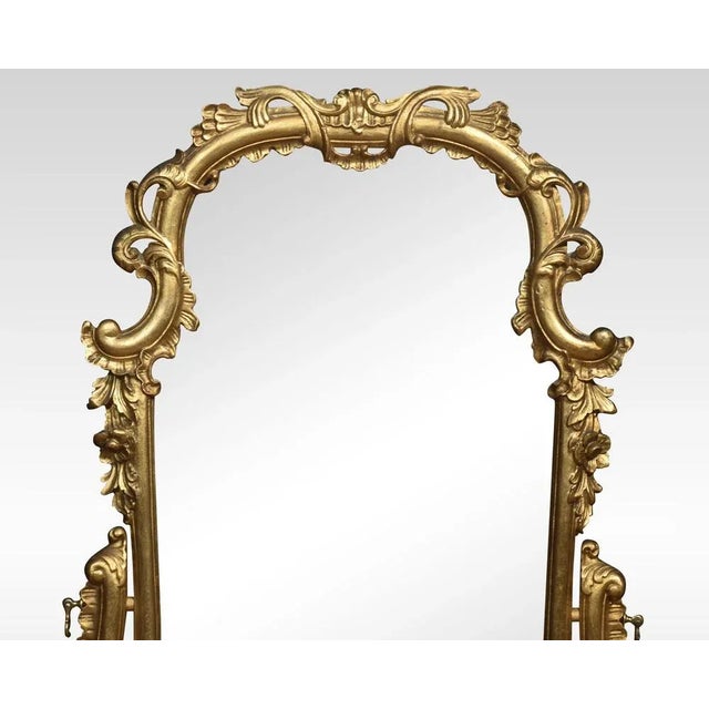 Italian giltwood and figured walnut dressing mirror of Rococo style, the long scrolled foliate frame mounted on scrolled...