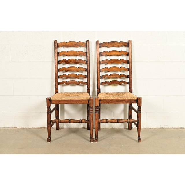 A gorgeous pair of English Country or Rustic European style ladder back dining chairs In the manner of Baker Furniture...