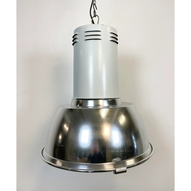 Industrial hall lamp made by Siemens in Germany during the 1980s. It features aluminium shade, iron top and iron grid. The...