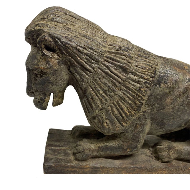 This is a fine carved naive sculpture depicting a recumbent lion. The lion is robustly carved with an expressive face and...