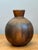 This vintage brown glazed stoneware vase embodies the understated elegance and organic sensibility of mid-century ceramic...