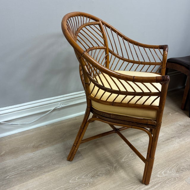 Authentic 1960’s bent rattan chair with buttercream yellow seat cushion.