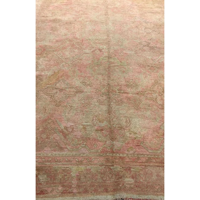An early 20th-century Turkish Oushak corridor-size rug in pale pink