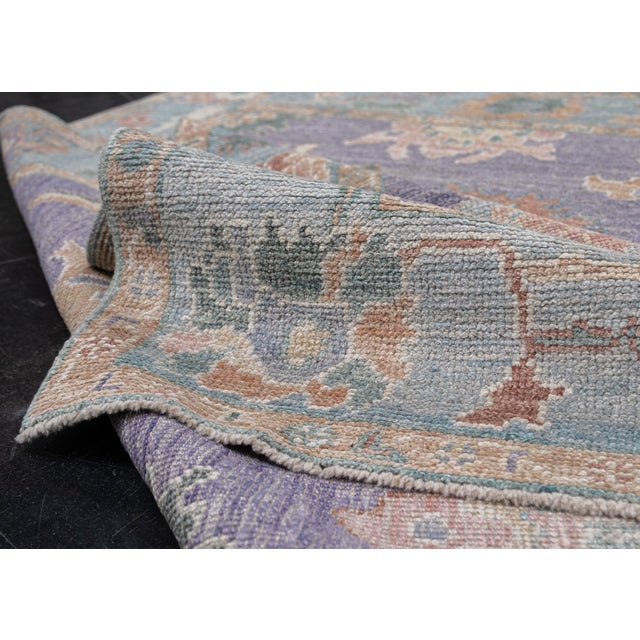 Turkish Oushak Rug Purple & Blue Floral Handwoven Wool Rug 4'11" x 6'10" This handwoven Turkish Oushak rug features a...