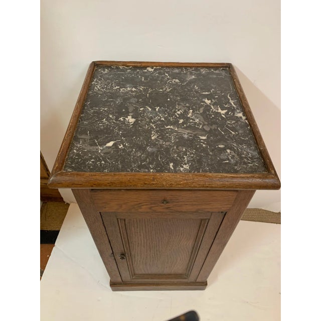 A handsome 19th century oak cabinet stand or side table having lively black and white marble top and one drawer with...
