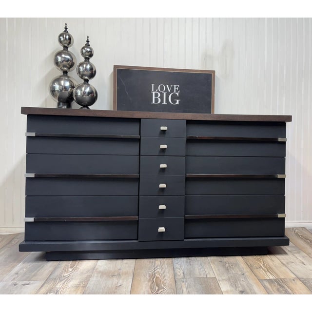 Mid-Century Modern finished in Black with Walnut Trim. Silver knobs and handles. 6 drawers with walnut and silver accents....