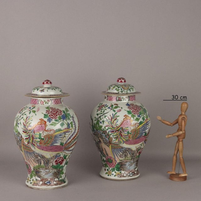 Pair of porcelain potiches with polychrome decoration depicting flowering branches, peonies and birds. Bud handle. This...