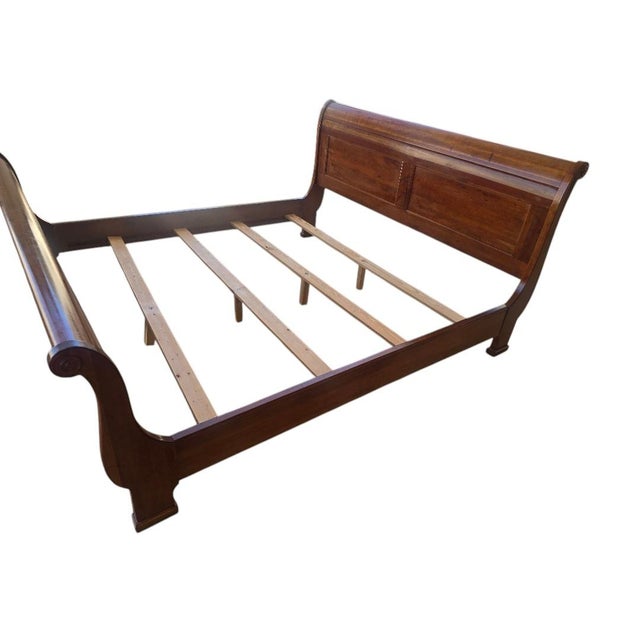 A handsome traditional king size sleigh bed featuring a rich cherry-toned finish and elegant paneled construction. This...