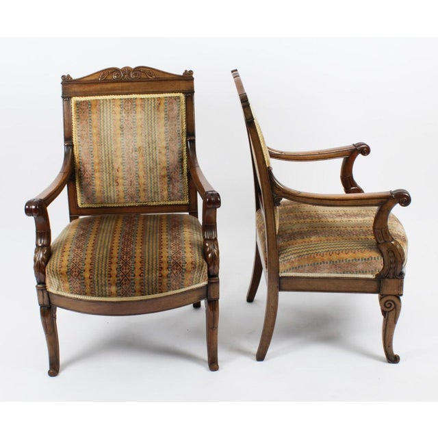 This is an elegant antique pair of french empire revival upholstered back mahogany armchair fauteuils, circa 1880 in date....