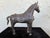 This striking vintage horse sculpture is finely cast in solid metal and features beautifully detailed ornamental saddle...
