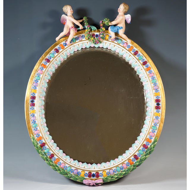 Rare large oval relief porcelain mirror: colourful oval lenses alternate with blue forget-me-not flowers, bordered on the...
