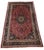 An impressive hand-knotted Persian Kerman rug featuring a richly saturated ruby-red field with an elaborate floral...