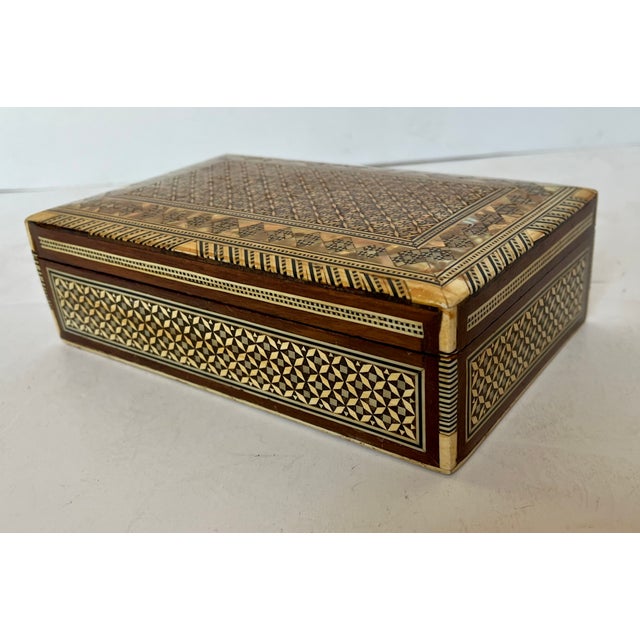 Moroccan style geometric design inlaid wood jewelry box. Red velvet lined. Hinged lid. All sides and top are decorated....