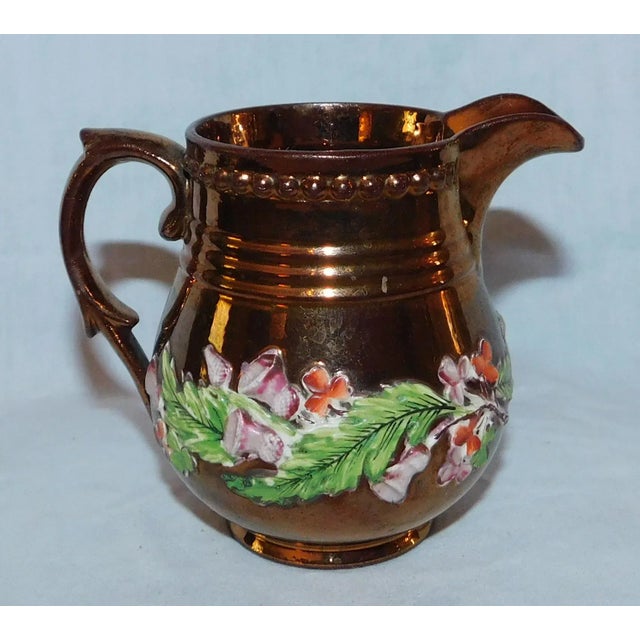 Sweet antique copper lustreware creamer with applied floral decoration